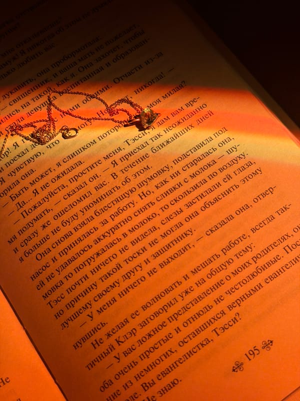 Gold necklace placed on open Russian book in Chaikovsky