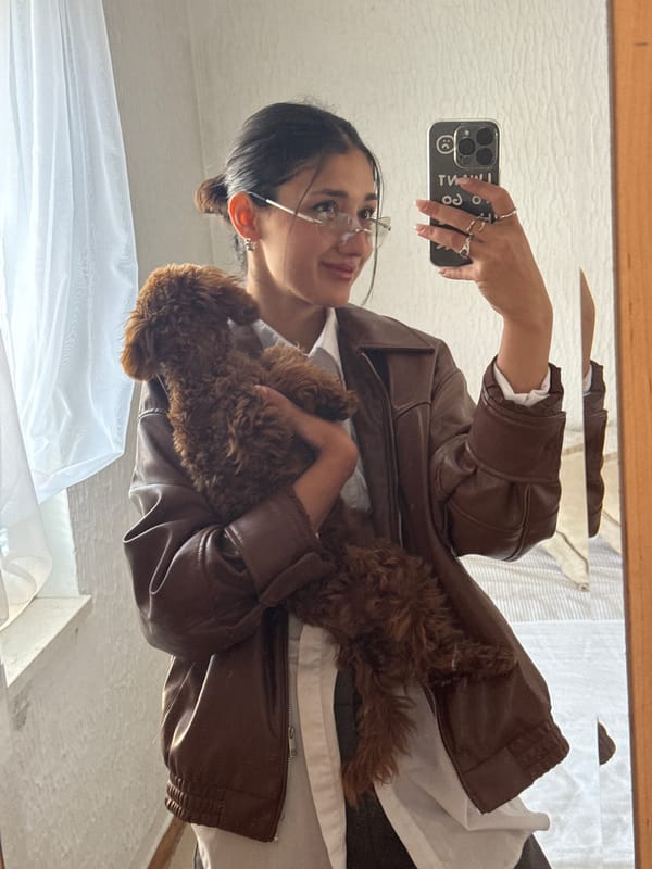 Woman takes mirror selfie with brown poodle in Sutomore