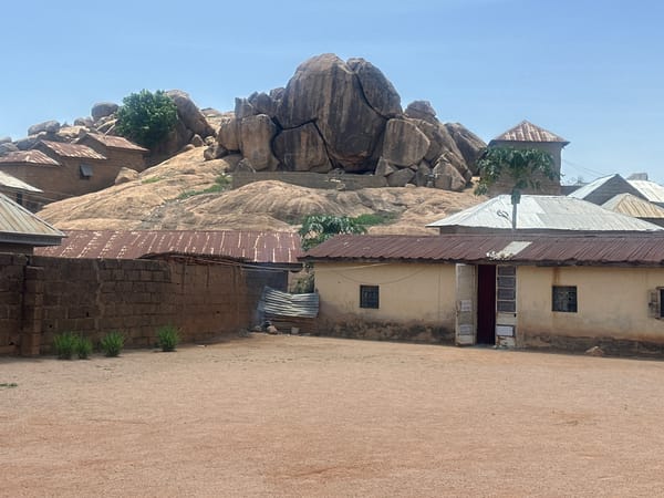 Rural Jos landscape documented showing homes around rocky outcrop