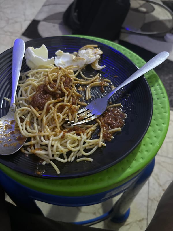 Spaghetti meal and HP laptop on a desk in Rido