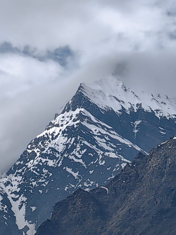 Snow-capped peaks and a hillside temple in Yamling, India