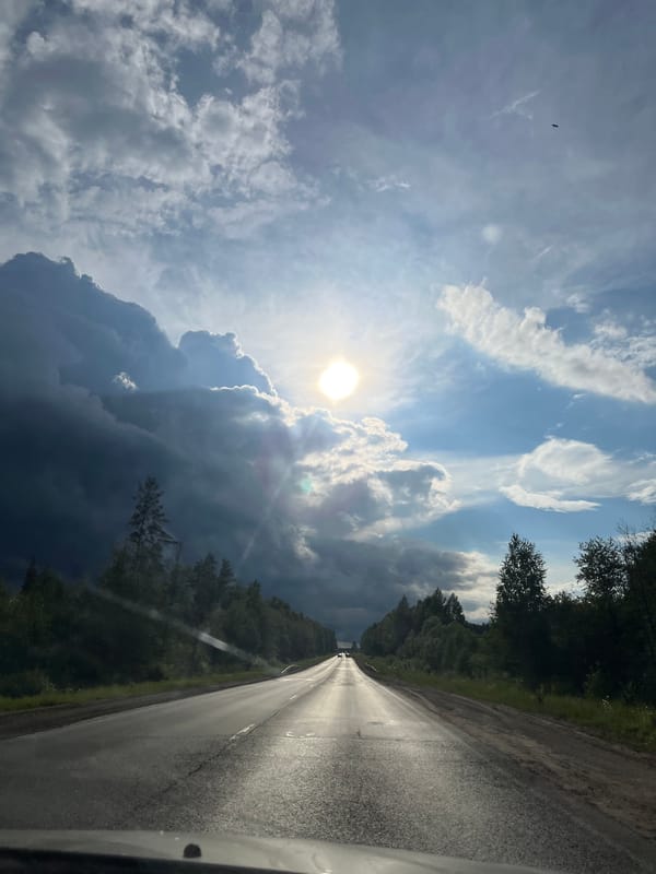 Storm clouds gather over rural road in Гаревая, Russia