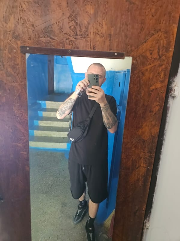 Mirror selfie in Codru, all-black fit and arm tattoos