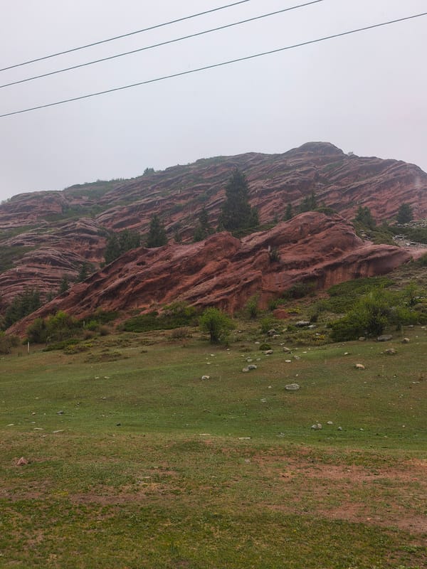 Red rock formations observed under overcast skies in Kyrgyzstan