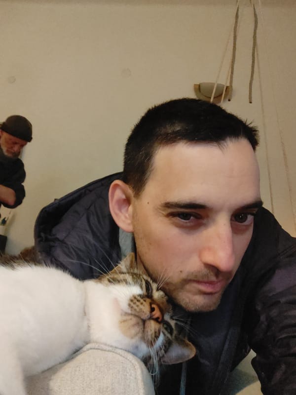 Man rests with white tabby cat on chest