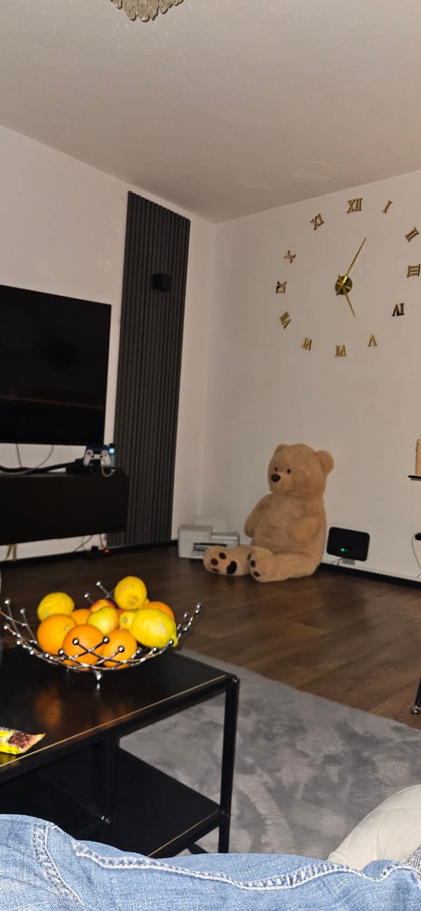 Interior scene captured in Gütersloh showing clock, teddy bear