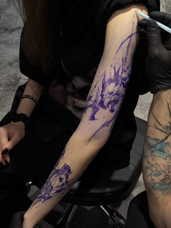 Tattoo artist traces abstract design on client's forearm in Moscow