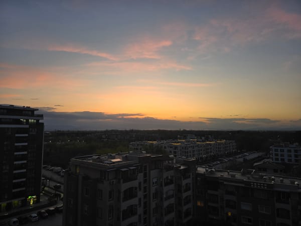 Sunset captured over water and cityscape during evening hours