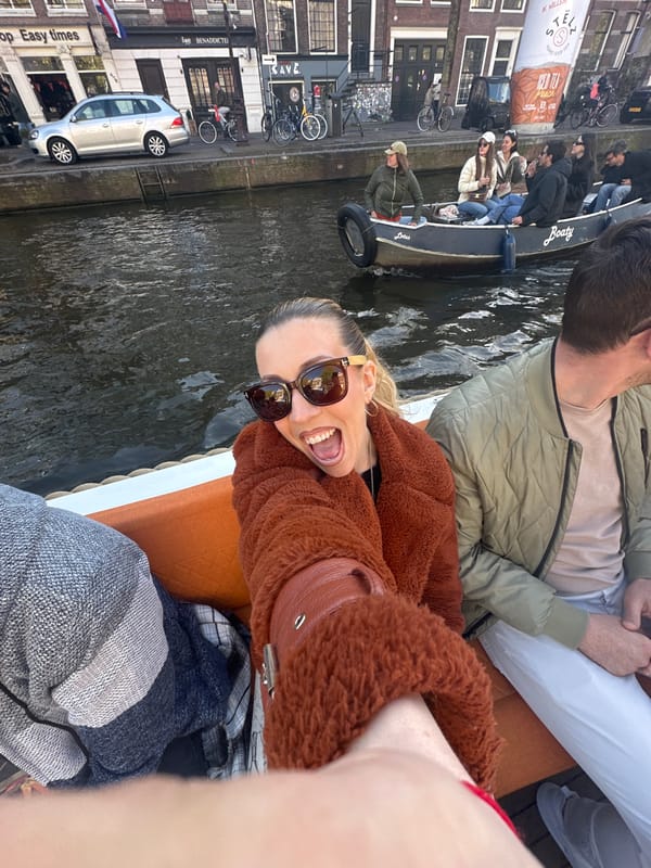 Canal boat tour navigates festive Amsterdam waterways during King's Day