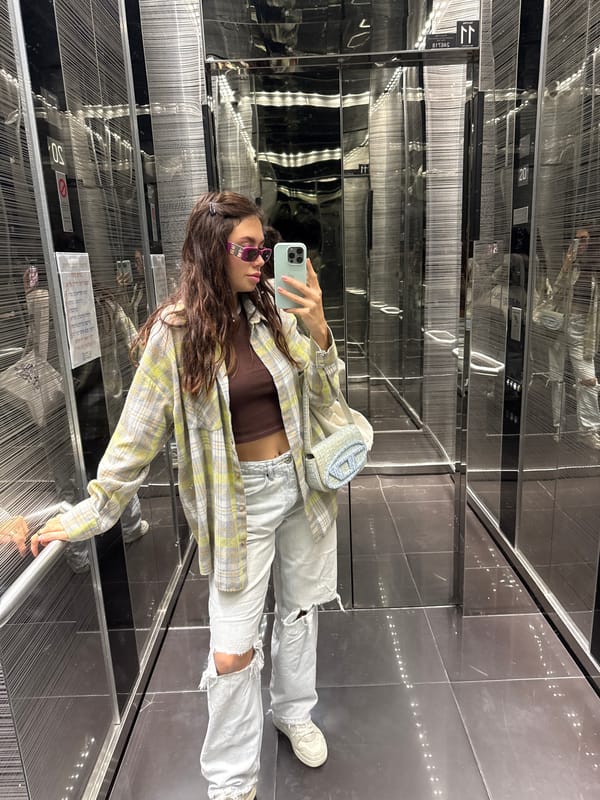 Woman takes elevator selfie in casual outfit