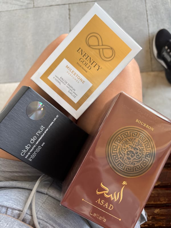 Person displays perfume collection while drinking energy drink