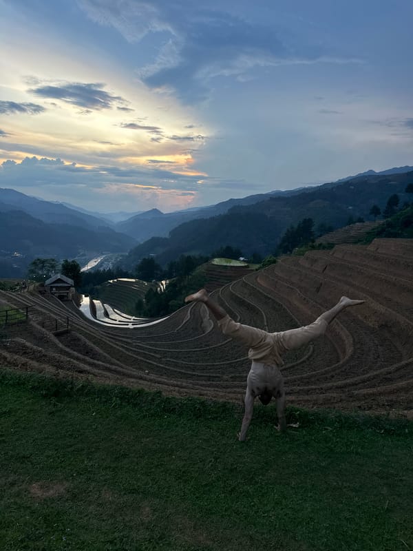 Tourist poses at Vietnam's terraced rice fields during twilight