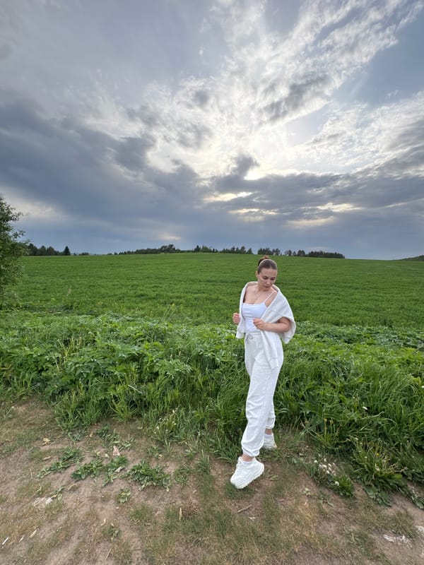 Woman in white poses on rural road in Lukintsy