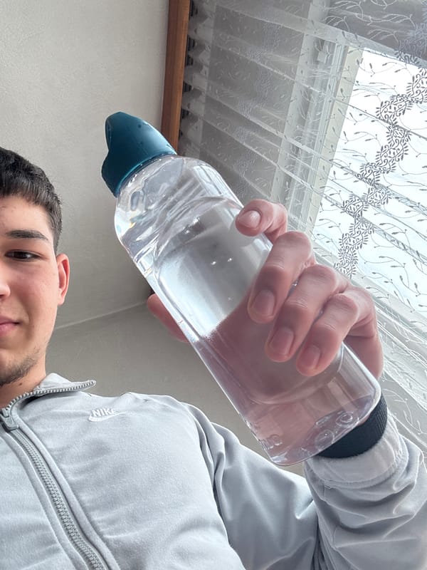 Young man photographed drinking water indoors in Zlatograd, Bulgaria