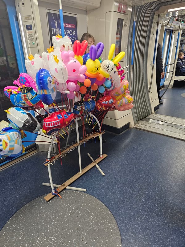 Balloon vendor sells animal-shaped balloons on Moscow Metro train