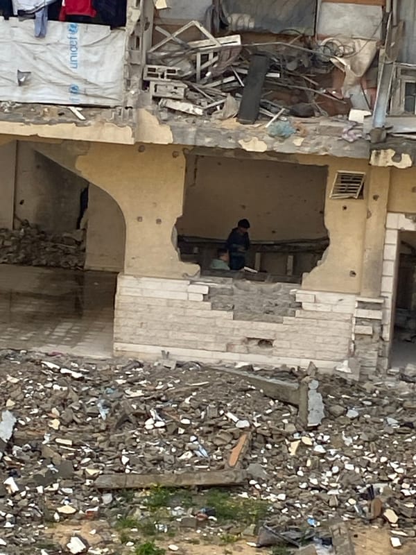 Children play amid damaged buildings in Khan Yunis