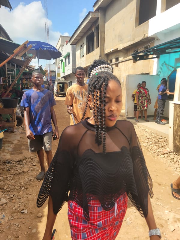 Woman in traditional attire photographed in sunlit Onitsha scene
