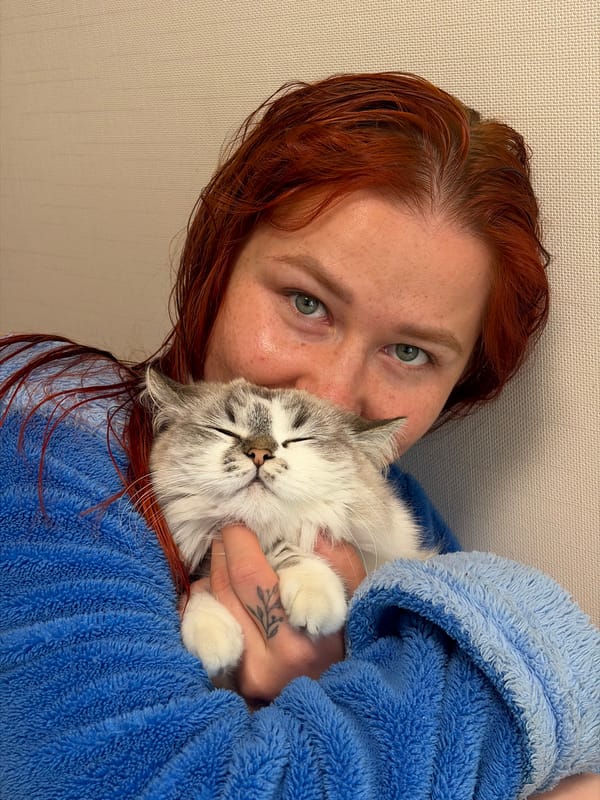 Woman in blue robe cuddles sleeping kitten in Rostov-on-Don