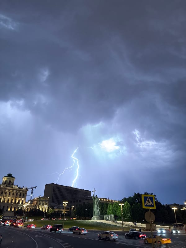 Lightning strike illuminates city buildings during nighttime storm