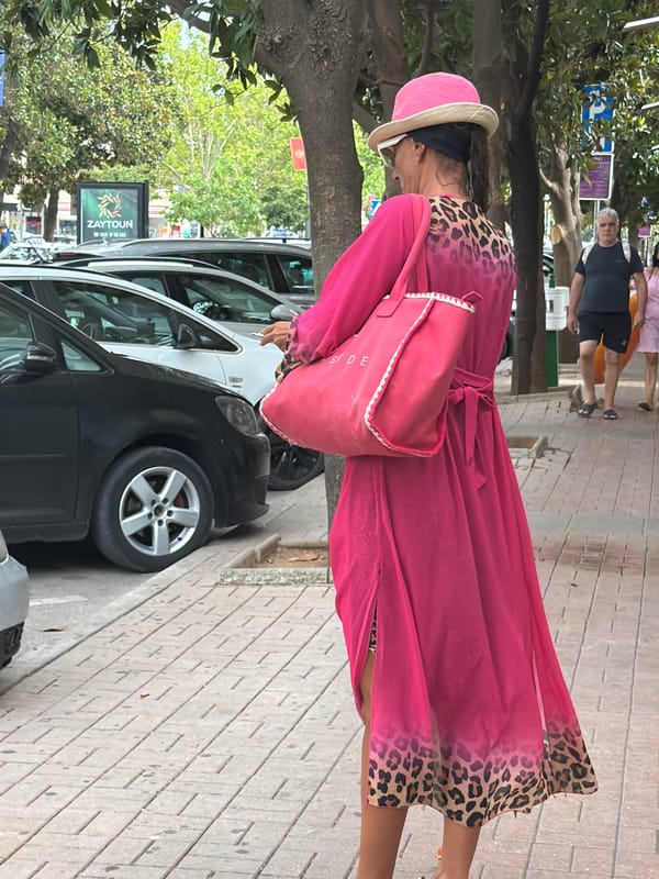 Foot traffic on a Budva sidewalk, bold looks and luggage in tow