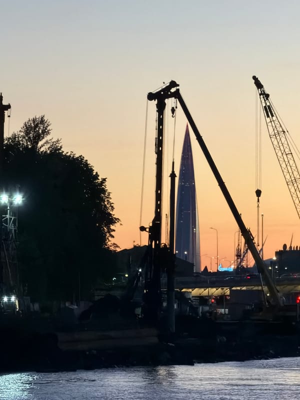Neva River waterfront at dusk, cranes and fading light