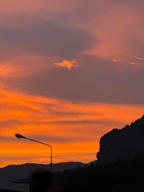 Vivid sunset over Ban Na Tin with mountain silhouette