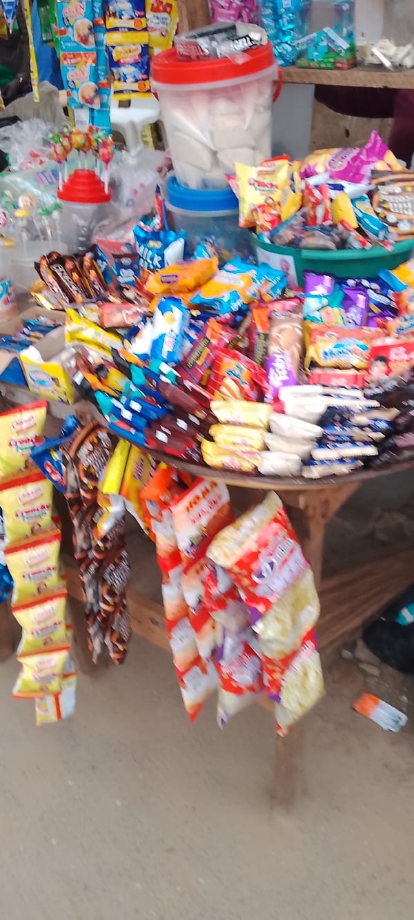 Lagos street market stalls selling snacks, onions, and yams