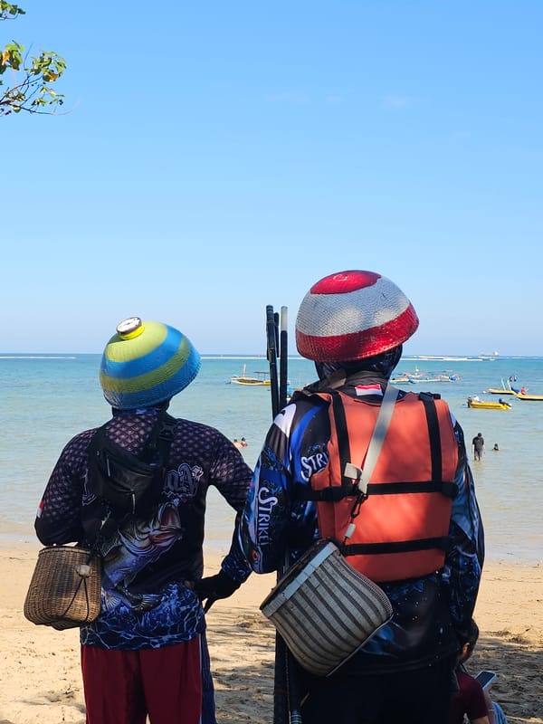 Busy Bali coastline morning: beach life, fishing, and passing boats
