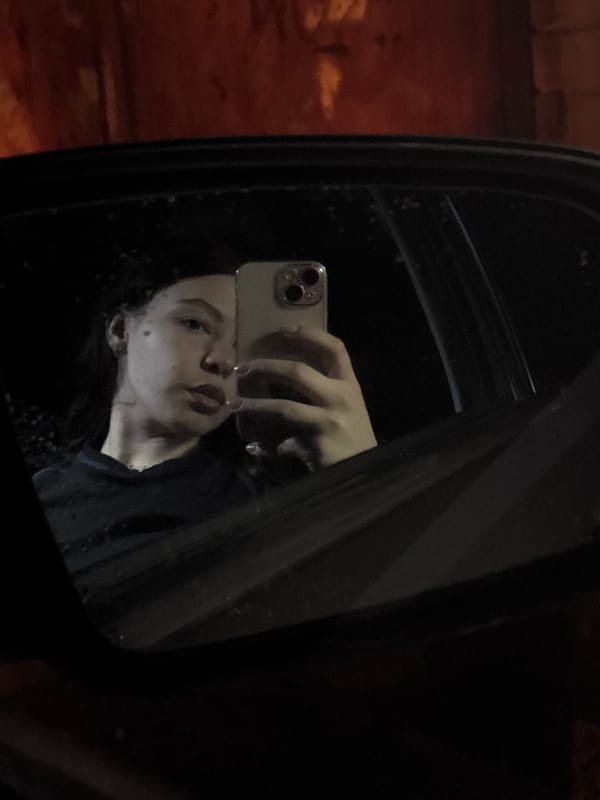 Person takes iPhone selfie reflected in side mirror in Perm