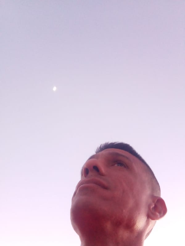 Person observes crescent moon at stadium during dawn