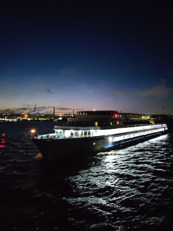Illuminated cruise ship navigates nighttime waters near Cherepovets, Russia