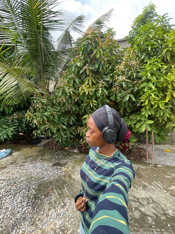 Woman in black head covering photographed among greenery in Nigeria