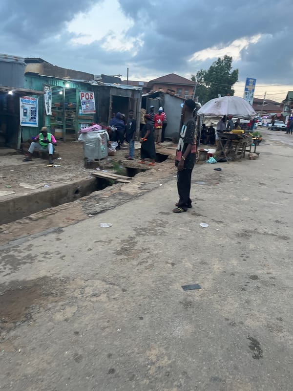 Jos streets at dusk: foot traffic, vendors, and police patrol presence