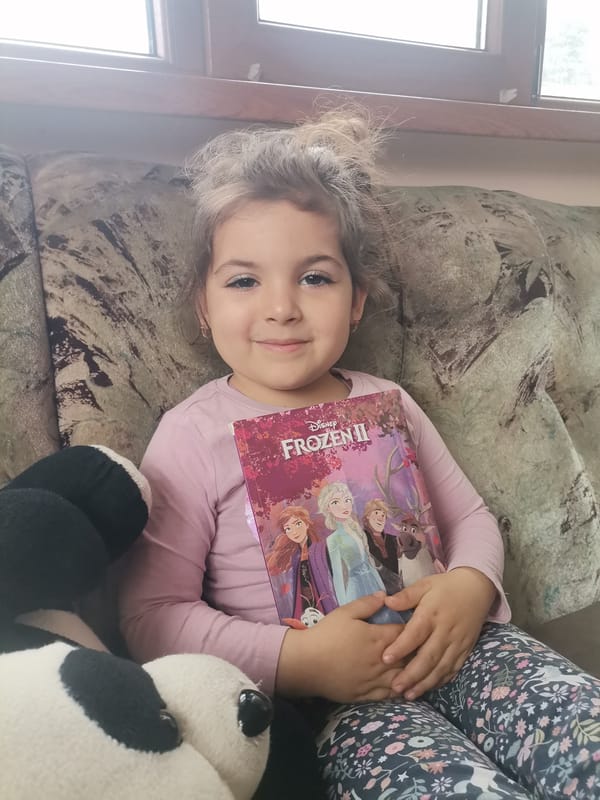 Girl reads Frozen II book at home in Bulgaria