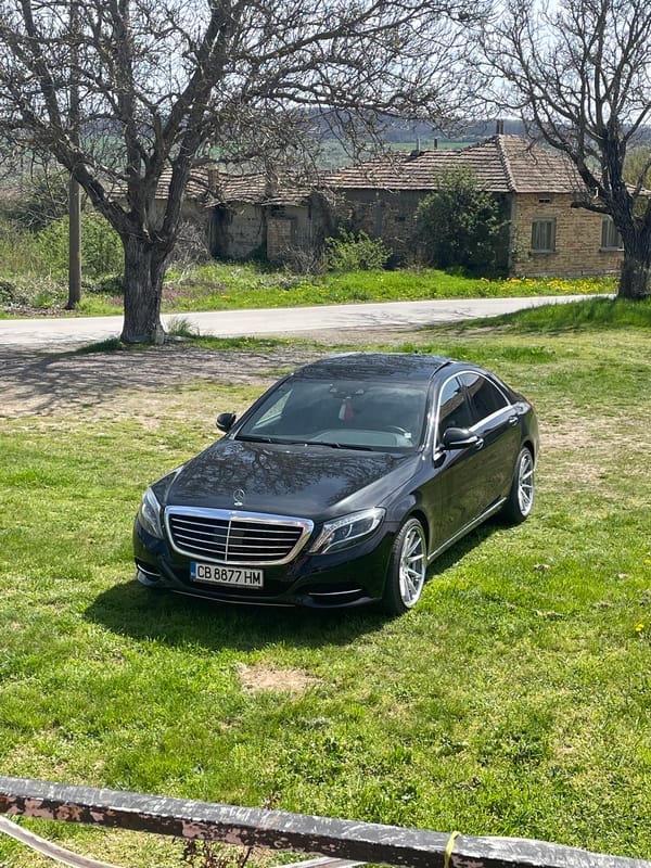 Mercedes sedan parked on grass in rural Bulgarian village