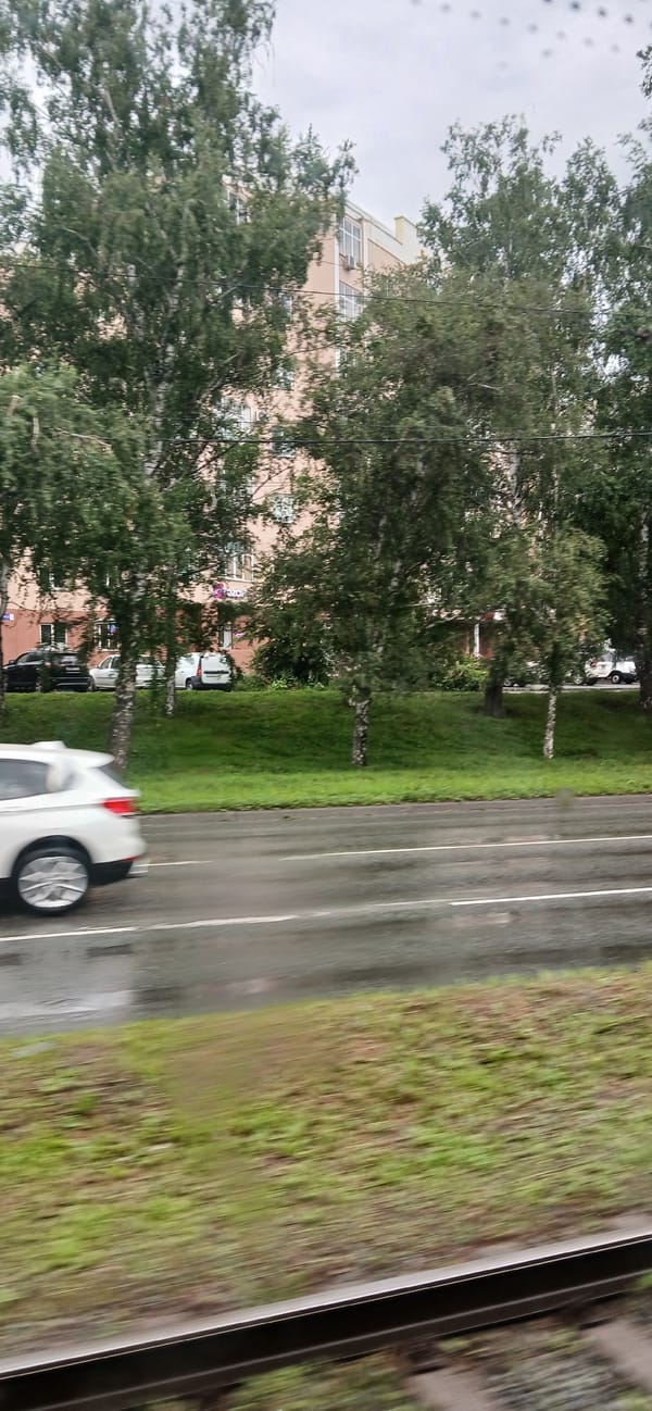 Rainy morning transit through Chelyabinsk streets and rail crossings