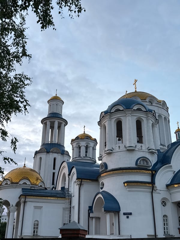 Moscow park at golden hour, church and pathways under a dramatic sunset