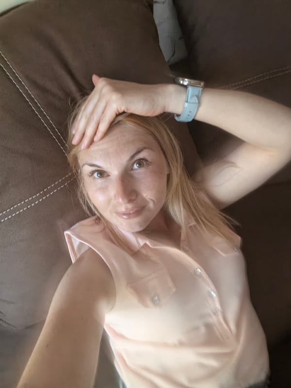 Woman enjoys strawberry snack on sofa during quiet moment
