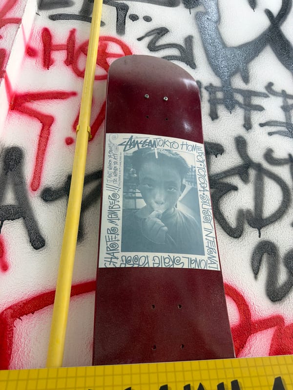 Skateboard with sticker spotted on graffitied wall in Chalong