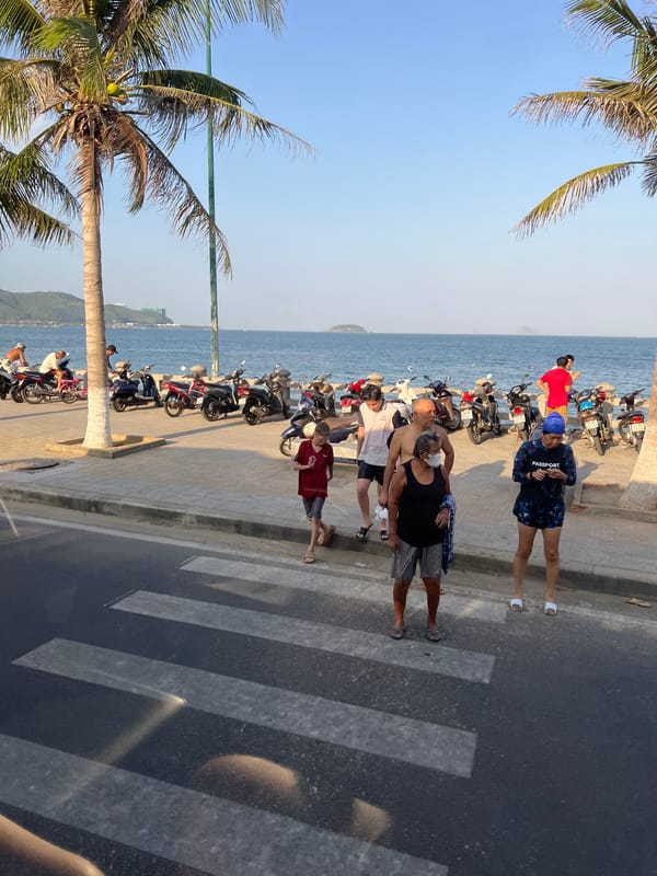 Morning scooter traffic flows along Nha Trang's beachfront promenade