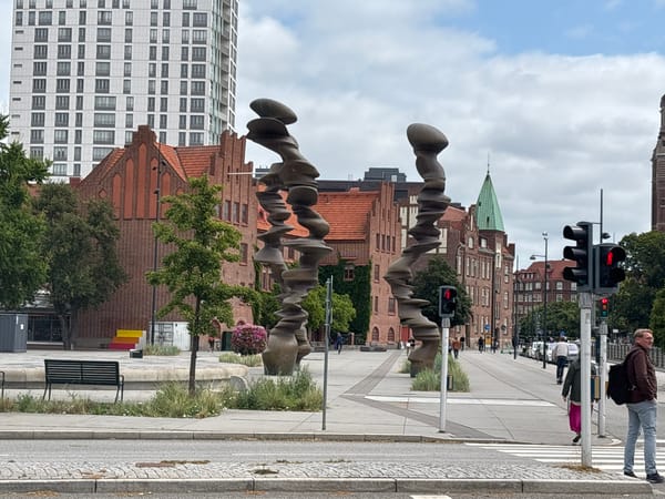 Public sculptures in a plaza, metallic and bronze forms on display