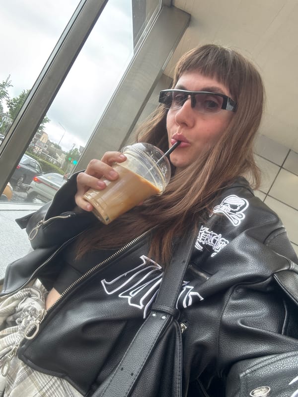 Person drinks beverage on overcast Moscow street morning