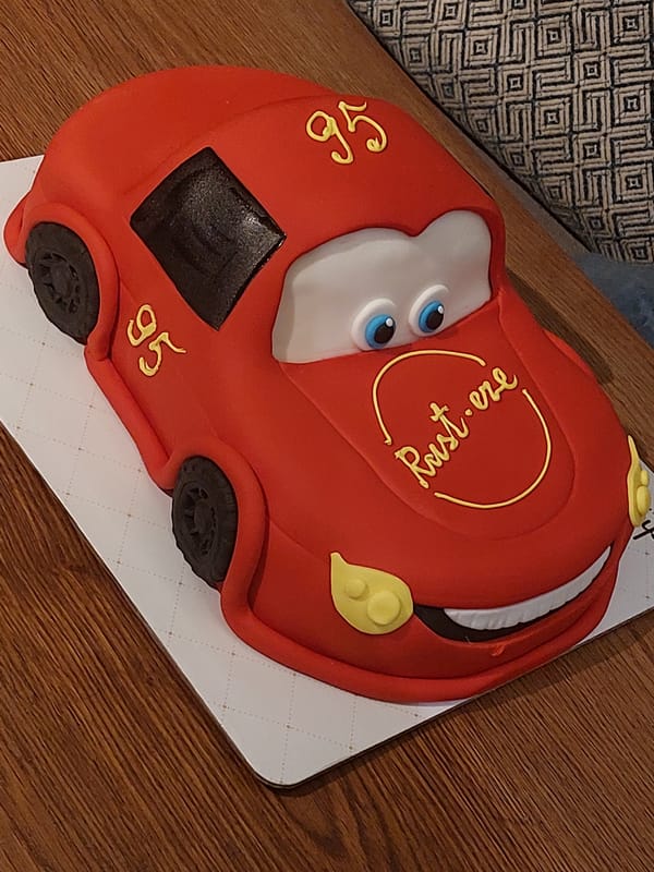Celebration items captured: themed cake, flower arrangements, rose bouquet