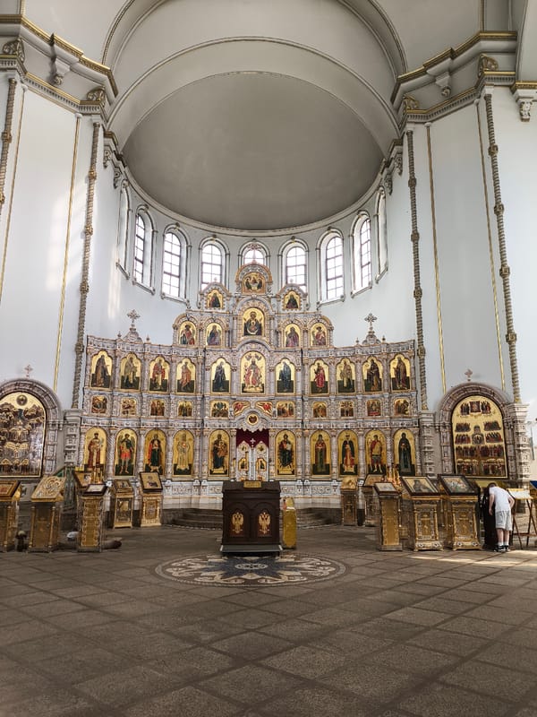 Inside an ornate Orthodox church, gilded and sun-lit
