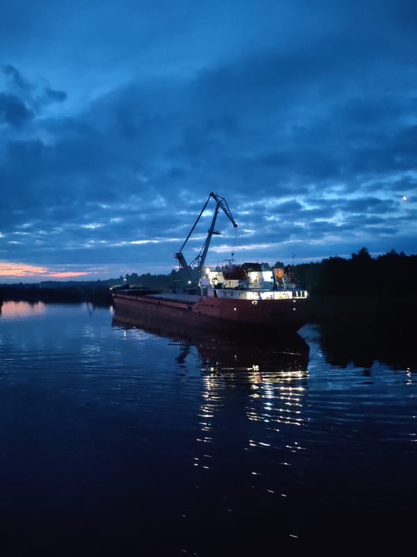 Cargo barge and crane docked at dusk on a Russian river