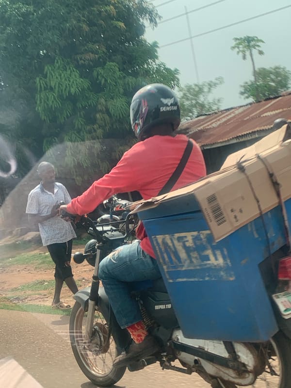 Motorcycle rider transports cargo containers in Maigizo, Nigeria