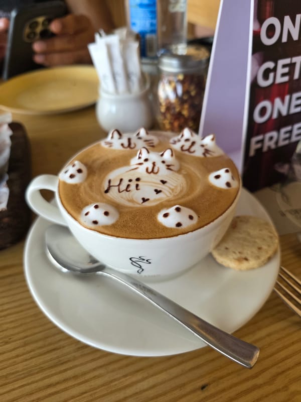 Cat-face latte art on a wooden table in Mumbai