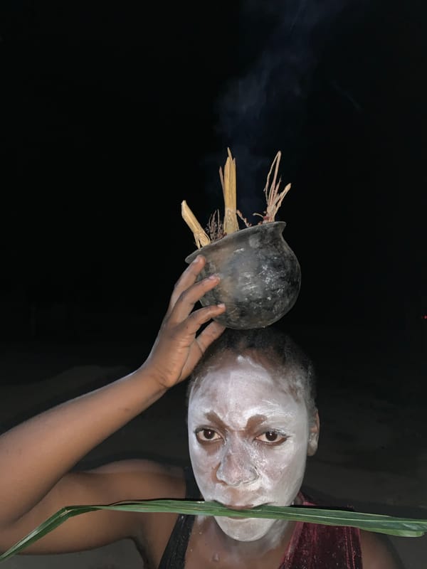 Person with white face paint holds smoking pot in Nigeria