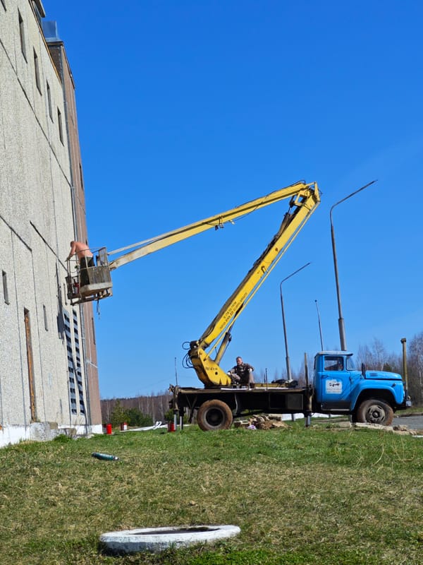 Workers operate aerial lift during maintenance in Markovskii, Russia