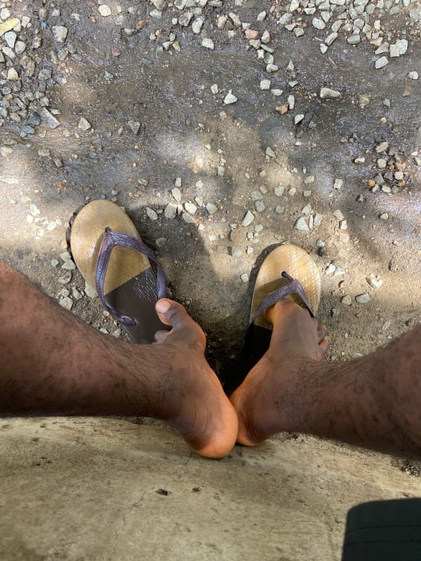 Person in flip-flops photographed standing on rocky ground in Nigeria